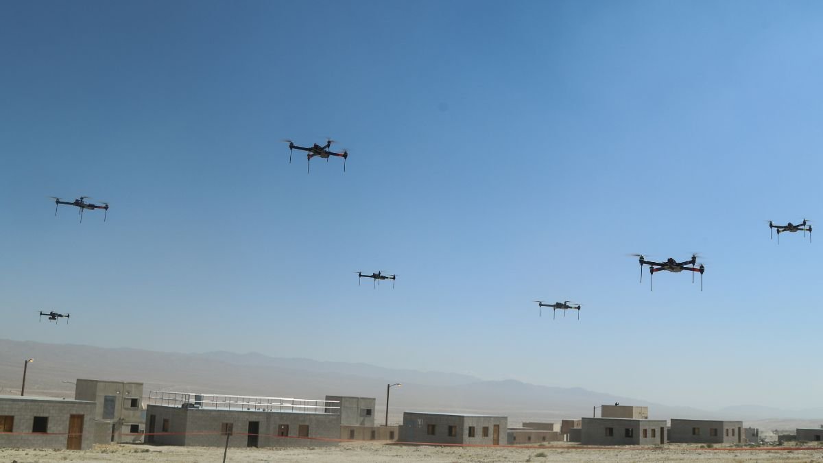 Military drone swarm operating during a field exercise representing the US Replicator programme and Pentagon investment in autonomous unmanned systems