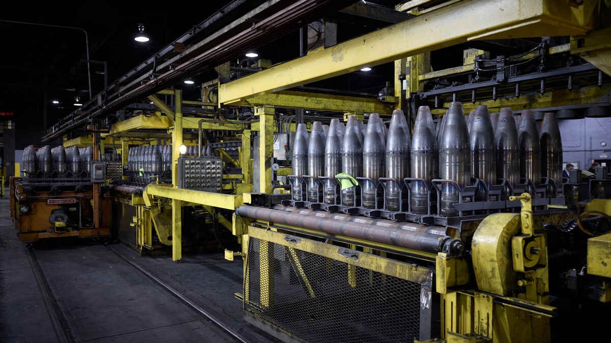 Artillery projectiles moving through an industrial ammunition production facility