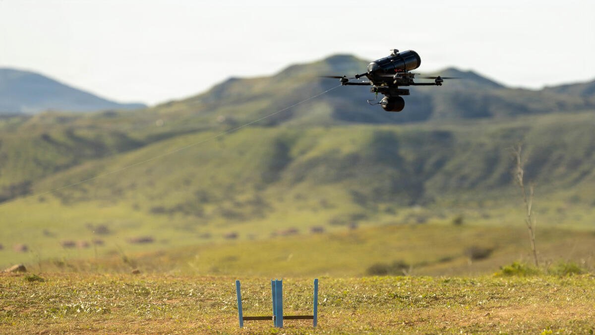 Fiber-optic cable guiding an FPV drone in flight, illustrating jam-resistant guidance technology used in modern drone warfare